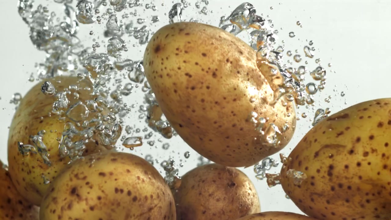 Patate fresche che cadono nell'acqua al rallentatore