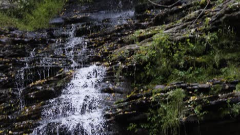 tilting shot showing the full rocky waterfall coming from the river gorge