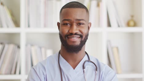 Video-of-happy-african-american-male-doctor-looking-at-camera