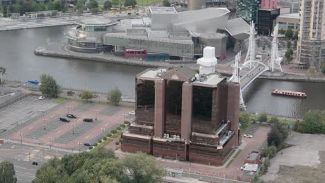 edificio del muelle oeste con vidrio esmaltado de bronce con el lowry, los muelles y el puente del milenio en el fondo en salford, manchester, inglaterra, reino unido