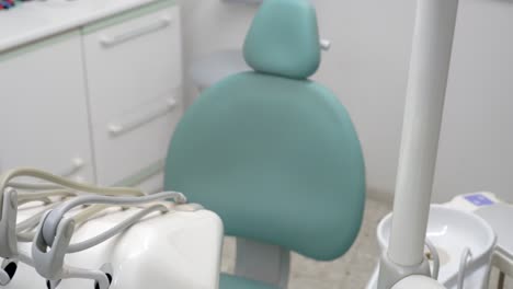 zenithal view of a blue dentist's chair in an empty dental clinic with the necessary equipment ready to treat dental problems