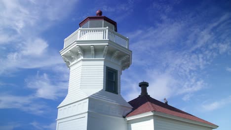 Umlaufender-Blick-Auf-Einen-Alten-Leuchtturm-Vor-Einem-Blauen-Himmel-Mit-Wolken