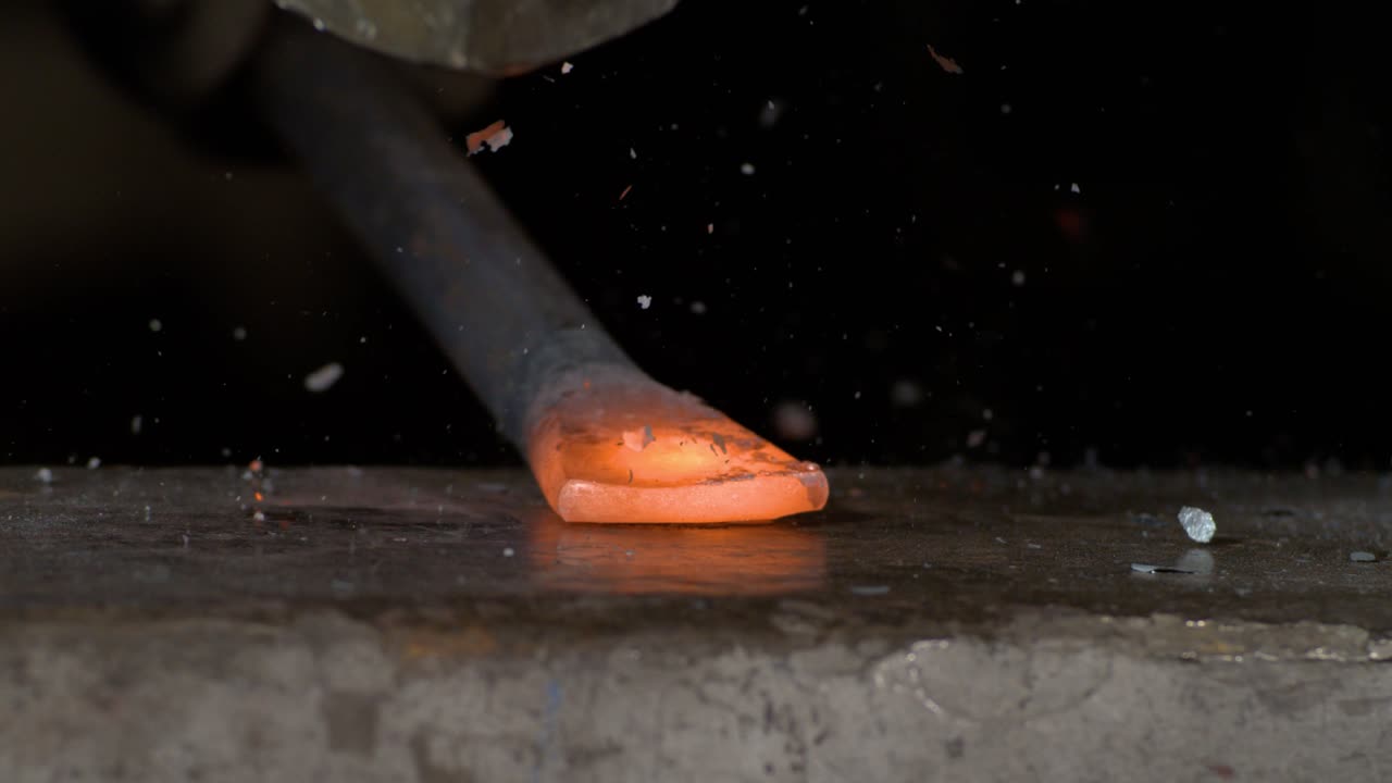 Blacksmith at work on an anvil shaping some steel in super slow motion