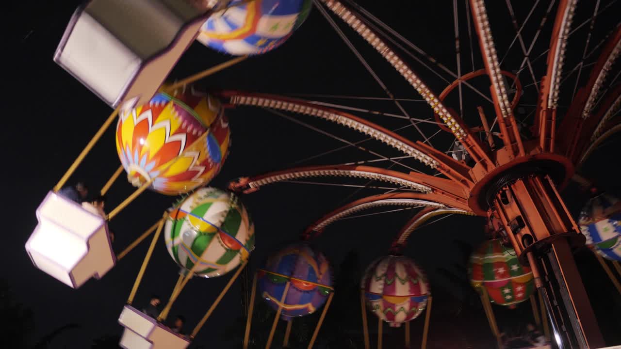 swinging fair ride al anochecer tonificado en divertido parque de atracciones extremo por la noche. actividades de fin de semana.