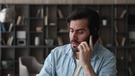 stressed young man hearing awful news at mobile phone call conversation.