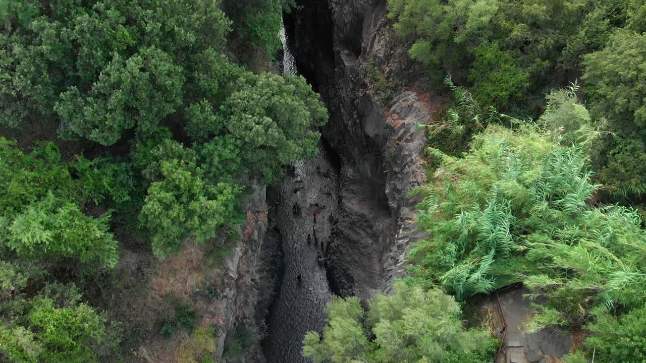 inclinación aérea de 4k hacia abajo: drone volando sobre las gargantas de alcantara, un impresionante canal de columnas de lava erosionadas naturalmente en barrancos, cañones y cuevas