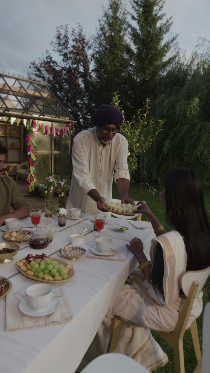 Indian Family Enjoying an Outdoor Dinner and Celebration in a Garden