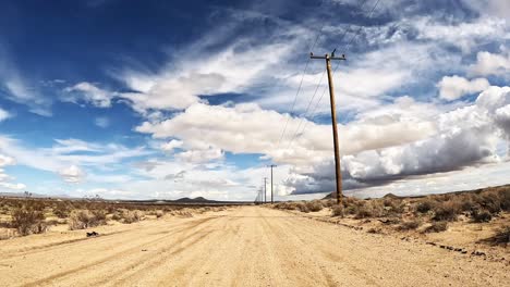 driving along a lonely dirt road in the mojave desert - driver point of view