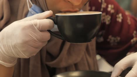 woman serving coffee with gloves