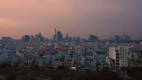 evening drone shot moving from right to left showing residential area of the city with large recognisable buildings in the background