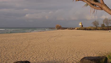 beach against cloudy sky at sunset in currumbin alley, gold coast, queensland, australia - wide shot