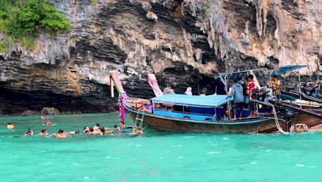 tourists snorkeling near a boat in krabi