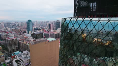 Anden-Spiegeln-Sich-Auf-Einem-Modernen-Wolkenkratzer-Aus-Glas,-Aufsteigender-Schuss,-Santiago,-Chile