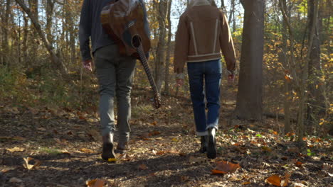 musicians-walk-on-trail-in-the-woods-in-the-fall