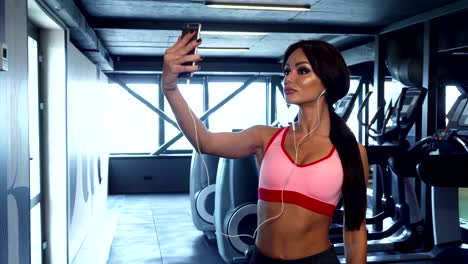 la dulce chica está haciendo una selfie en el fondo del gimnasio