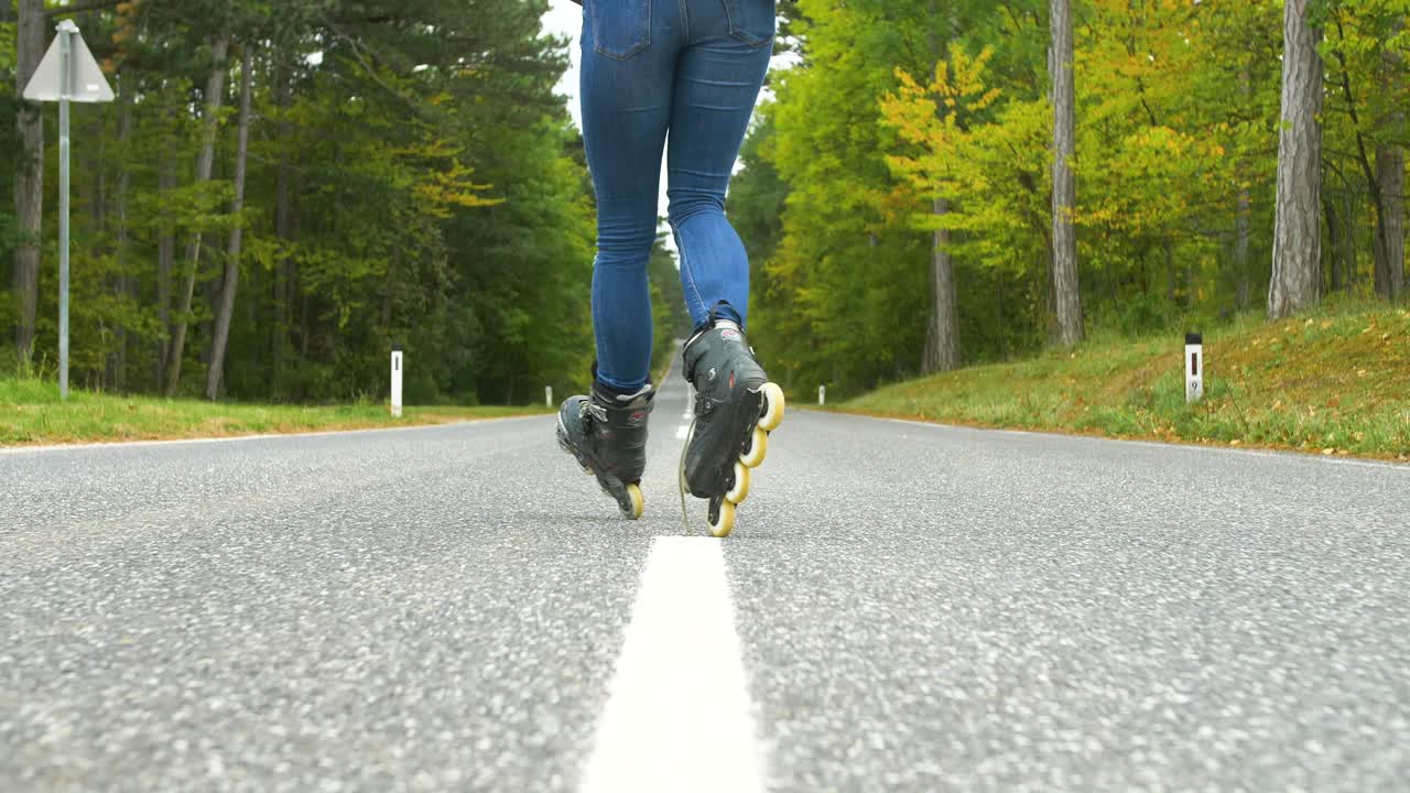 Young girl with inline skates on the street, having fun