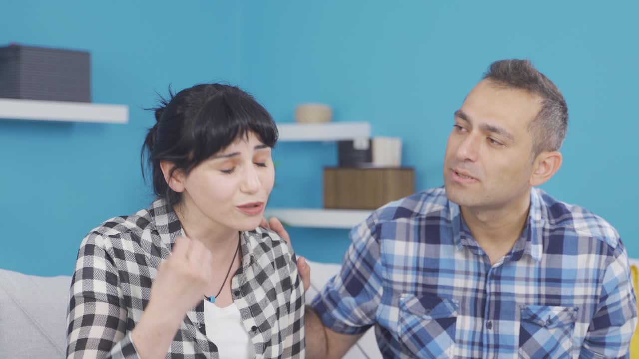 집에서, 여자는 긴장하고 남편은 그녀를 진정시 ⁇ 니다.