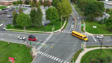 yellow school buses at intersection in american suburbia