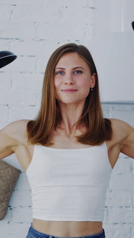 pretty female with frying pans at home. muscular young woman holding two empty frying pans. healthy housewife posing to camera. vertical video