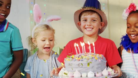 animation of confetti falling over boy holding birthday cake at children's party