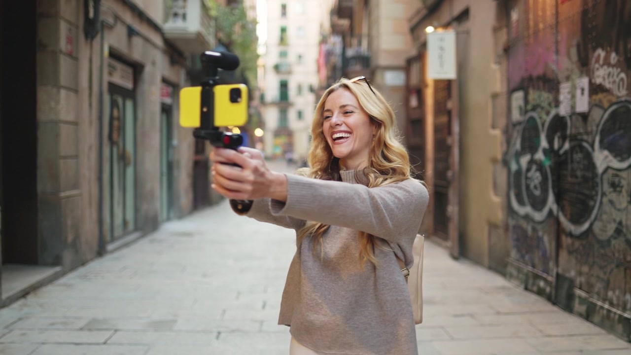 Giovane donna felice che fa vlogging con lo smartphone su una strada cittadina