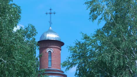 torre de la iglesia con una cruz y cúpula