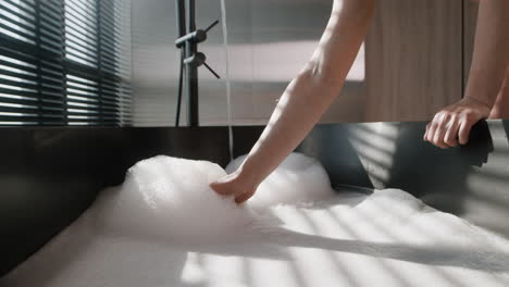 person adding bubbles in a modern black bathtub