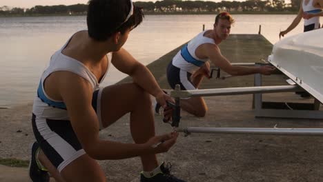 male rowers preparing the boat before practice