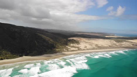 aerial pan at te werahi beach, cape reinga, showing the peninsula