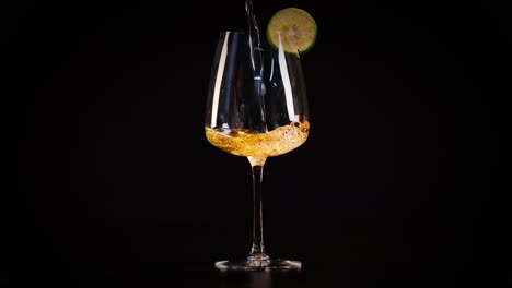 glass with lime slice on dark backdrop