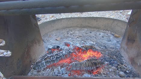 loop of campfire with a low flame and hot coals