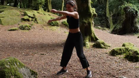 Happy-young-hispanic-woman-practicing-capoeira-in-the-woods