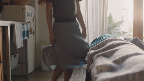 happy young woman dancing at home having fun celebrating summer vacation enjoying playful dance to celebrate successful lifestyle