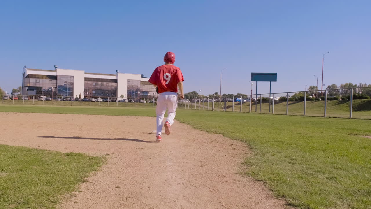 Follow shot of baseball player running toward base