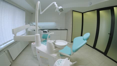 práctica dental moderna. silla dental y otros accesorios utilizados por los dentistas en azul, luz médica. ojo de pez