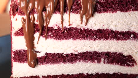 close-up of a red velvet cake slice with chocolate drizzle