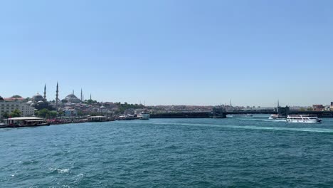 footage of ferryboats and cruise tour boats passing on golden horn part of bosphorus strait in istanbul. eminonu area and galata bridge are in the view.