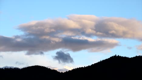 clouds move over silhouette mountains, timelapse