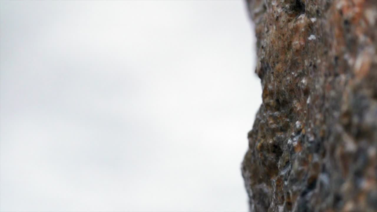 Snow falling on old stone megalithic rock dolmen, outdoors macro closeup