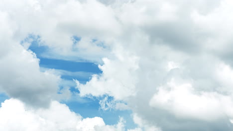 cumulus clouds move against a clear blue sky