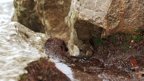 Waves-in-slow-motion-hitting-the-rocky-shore-and-crashing-with-power