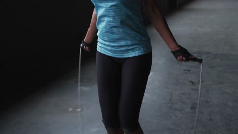 african american woman skipping the rope in an empty urban building