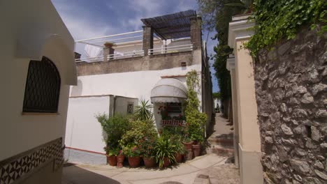 white building with a flower-framed window and an alley in anacapri's city center