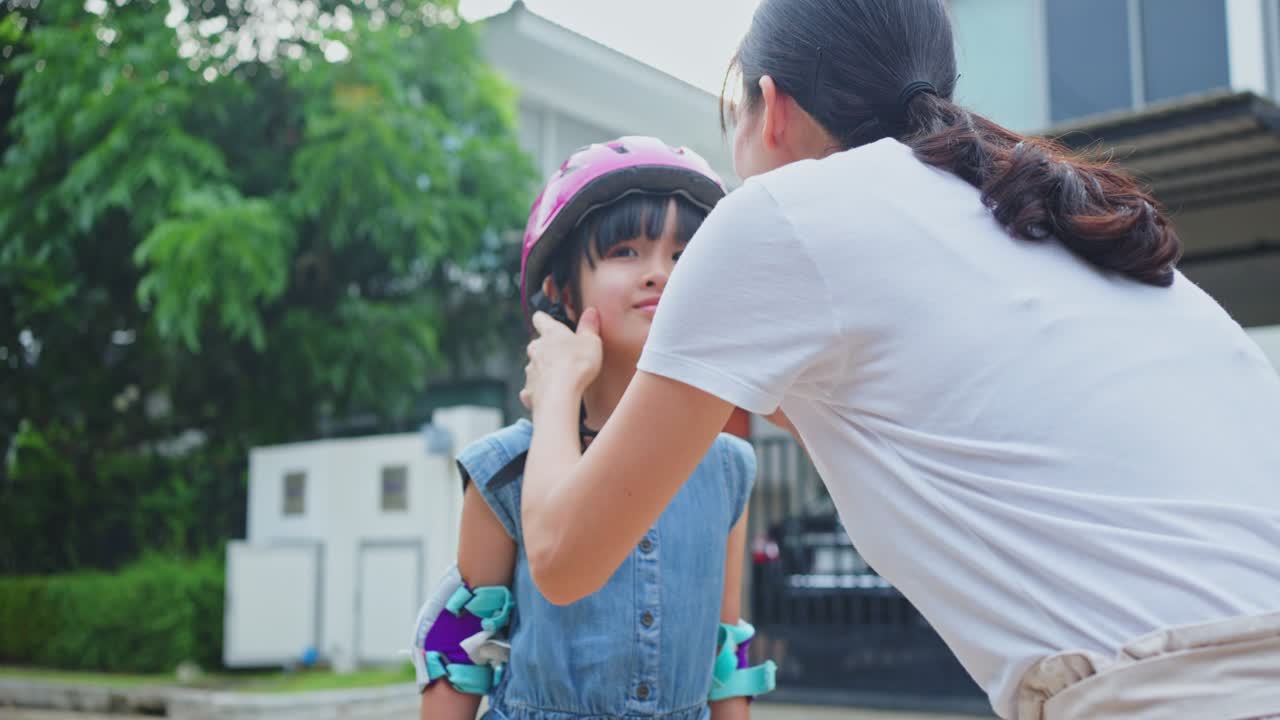어머니 가 딸 에게 안전 장비 를 착용 하는 데 도움 을 주고 있다