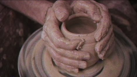 the potter makes a jug of clay. vintage effect. a man makes a vase on a potter's wheel