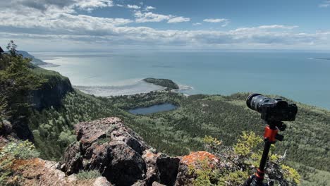 dslr camera in tripod stands on the edge of cliff