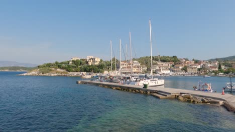 toma panorámica del puerto de kassiopi con veleros atracados, corfú