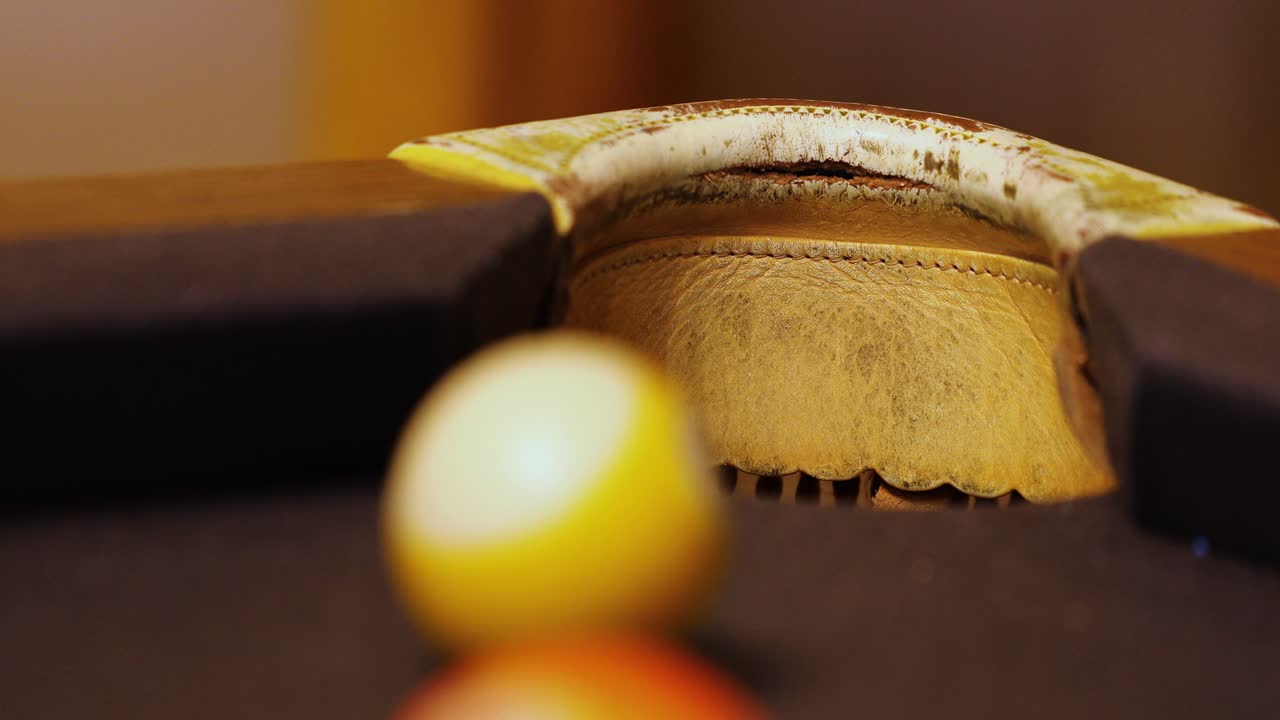 bola de billar cae en el bolsillo de la esquina de la mesa de billar