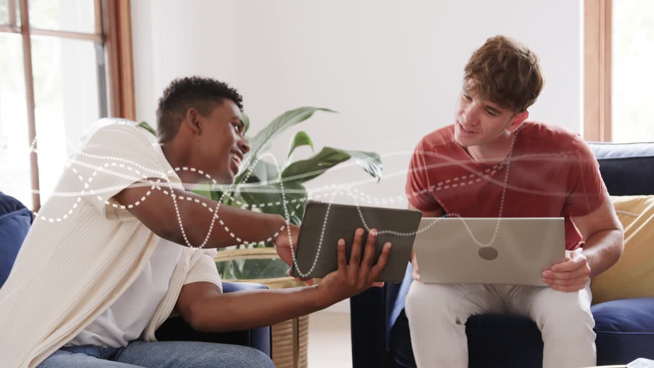 Two men, left man turning tablet to right man with laptop, waveform overlaying screens, learning