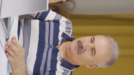 vídeo vertical de un anciano trabajador de la oficina en casa teniendo éxito.